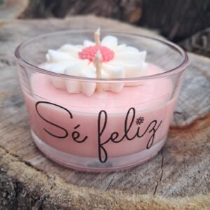 Vela aromática de cera de soja rosa pastel en envase de vidrio bajo y ancho con una margarita blanca artesanal y frase Sé Feliz de la marca MAKA Uruguay.