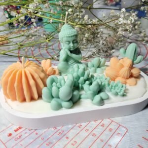 Vela de soja decorativa con figura de Buda zen y suculentas de cera en tonos pasteles hecha por MAKA en Rocha.